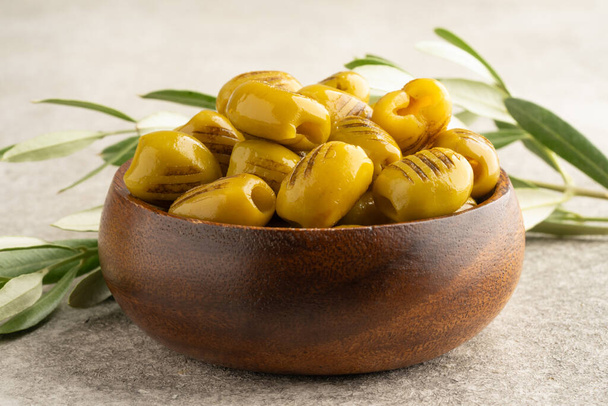 Gegrillte grüne Oliven auf Holz Hintergrund - Foto, Bild