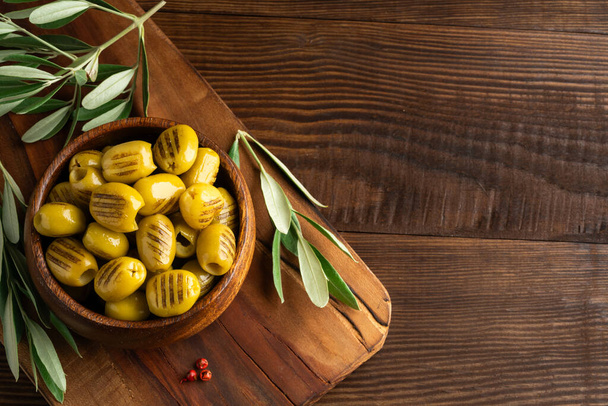 Grilled green olives on wooden background - Photo, Image