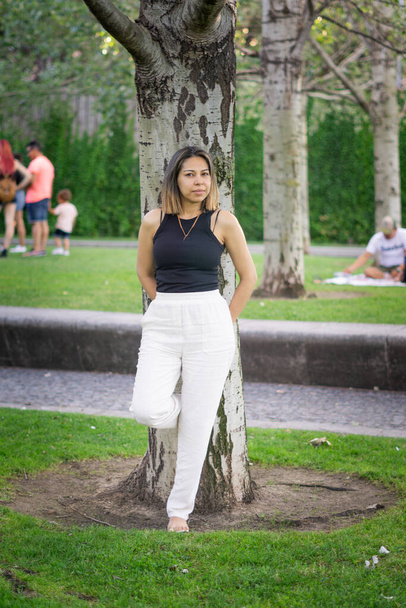 giovane donna appoggiata ad un albero in un pomeriggio d'estate - Foto, immagini