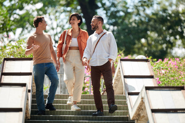 Grupo feliz de amigos hablando al bajar escaleras al aire libre - Foto, imagen