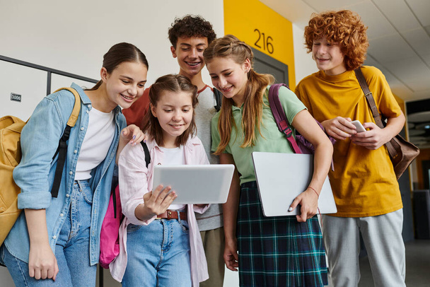 estudiantes adolescentes mirando la tableta digital y de pie en el pasillo, la tecnología y los adolescentes - Foto, Imagen