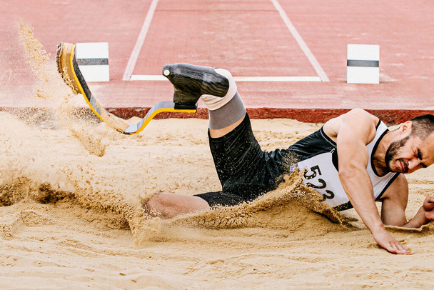 para lekkoatleta skok w dal, lądowanie piasek w zawodach lekkoatletycznych, letnie gry sportowe - Zdjęcie, obraz