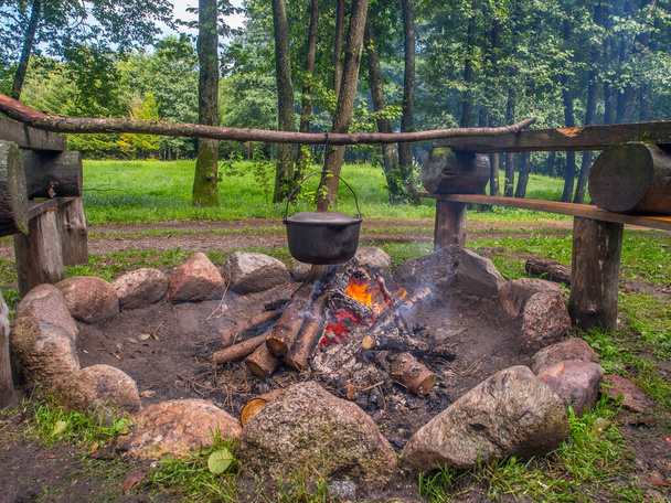 Kochen einer Mahlzeit am Lagerfeuer in Metallschiffen während einer Kanufahrt auf dem Fluss Wieprza. Polen. Europa. Osteuropa - Foto, Bild