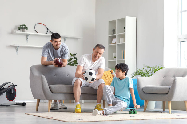 Sportlicher kleiner Junge mit Vater und Großvater zu Hause - Foto, Bild