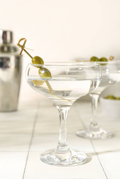 Copos de martini saboroso e azeitonas na mesa de telha branca - Foto, Imagem