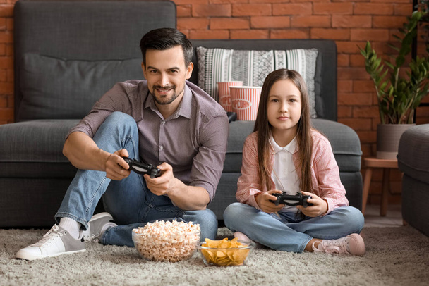 Vader met zijn kleine dochter spelen videospel thuis - Foto, afbeelding