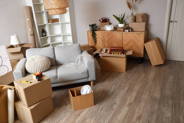 Pudełka kartonowe z rzeczami i sofą w salonie w dniu przeprowadzki - Zdjęcie, obraz