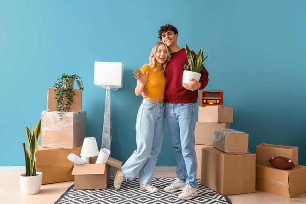 Счастливая молодая пара с ключами от новой квартиры в комнате в день переезда - Фото, изображение