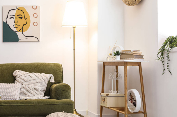 Belső tér elegáns nappali hangulatos zöld kanapéval, konzol asztal és izzó lámpa - Fotó, kép