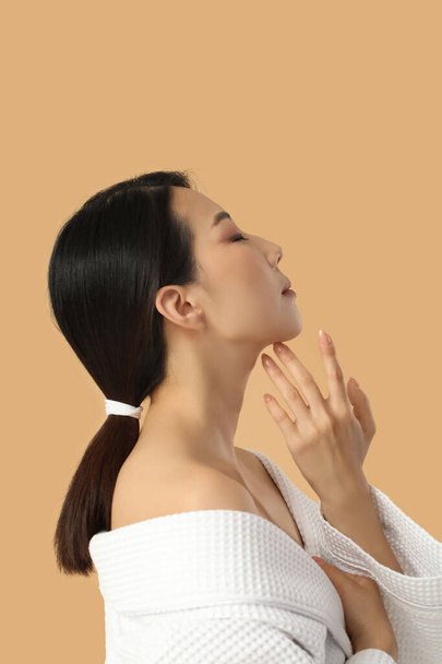 Bella giovane donna asiatica con pelle sana su sfondo beige - Foto, immagini