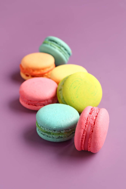Different tasty sweet macaroons on purple background - Photo, Image