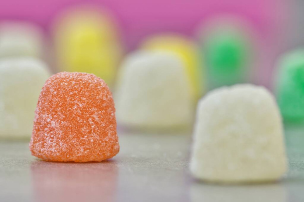 Gum Drops zuckerbeschichtete Bonbons, Makro-Seitenansicht auf einem Tisch mit selektivem Fokus. Beliebte Bonbons auf Basis von Gelatine, die weltweit hergestellt werden. - Foto, Bild
