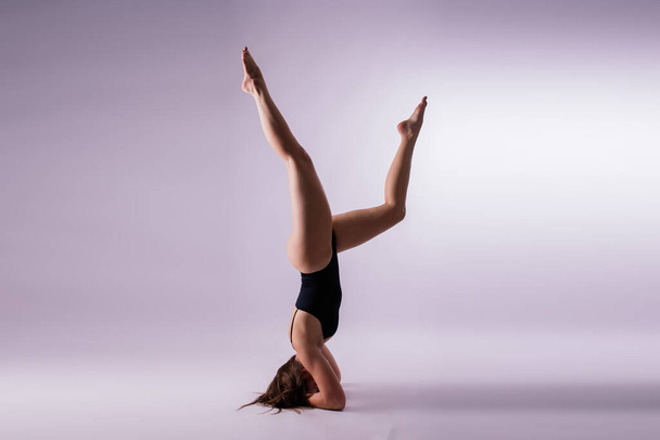 Femme athlétique en maillot de bain faisant du yoga, variation de pose de planche, magnifique studio d'exercice féminin - Photo, image
