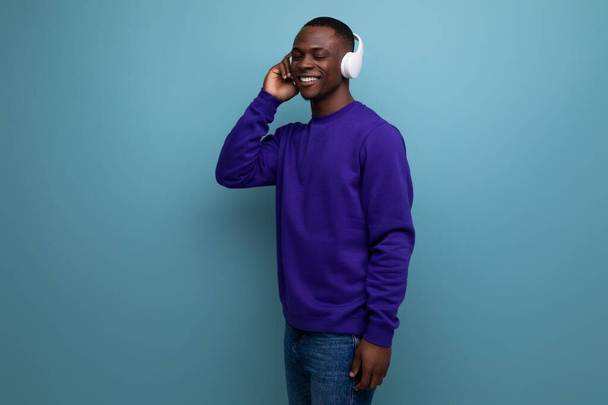 joven guapo que vive en América con auriculares inalámbricos escuchando música. - Foto, imagen