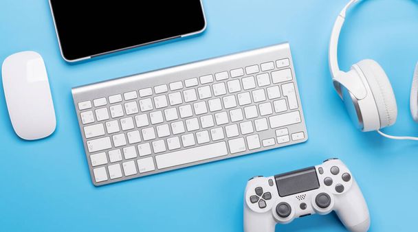 Gaming gear en tech accessoires op een blauwe achtergrond, perfect voor gaming en tech-gerelateerde thema 's. Vlakke plaat - Foto, afbeelding