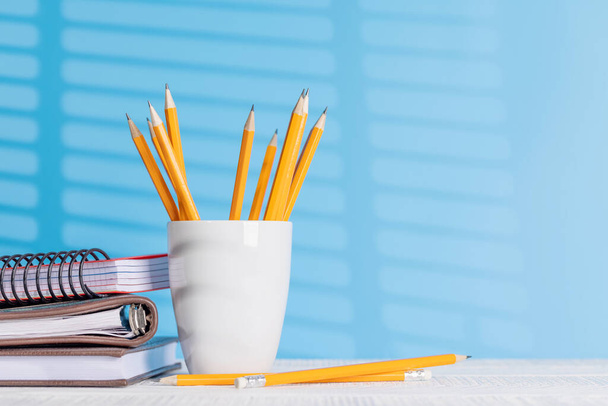 Una disposizione organizzata di matite e blocchi appunti su una scrivania dell'ufficio, che offre ampio spazio per le vostre idee creative o testo - Foto, immagini