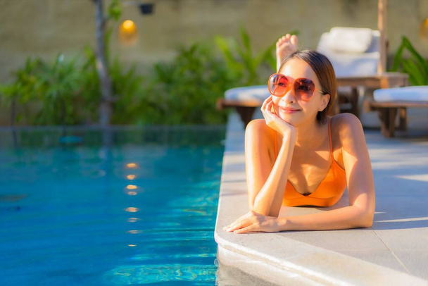 Retrato bonito jovem asiático mulher desfrutar relaxar ao redor piscina para lazer férias - Foto, Imagem