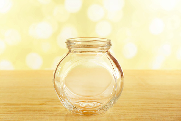 Empty glass bottle on table on bright background - Foto, Imagen