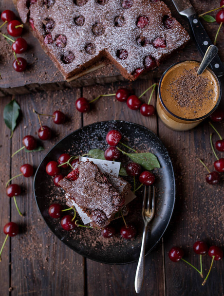 Rustic cake background with chocolate cherry cake and coffee on wooden table. top view - Photo, Image