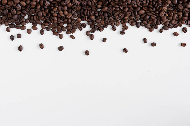 Μαύροι κόκκοι καφέ σε λευκό χρώμα με χώρο αντιγραφής - Φωτογραφία, εικόνα