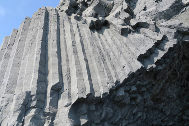 Die Basaltsäulen am Reynisfjara, dem berühmten schwarzen Strand Islands in der Nähe von Vik i Myrdal, bilden ein perfektes geometrisches Hintergrundmuster - Foto, Bild