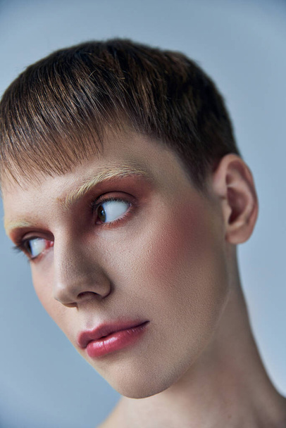 queer person with makeup looking away, grey background, beauty and visage, androgynous, portrait - 写真・画像