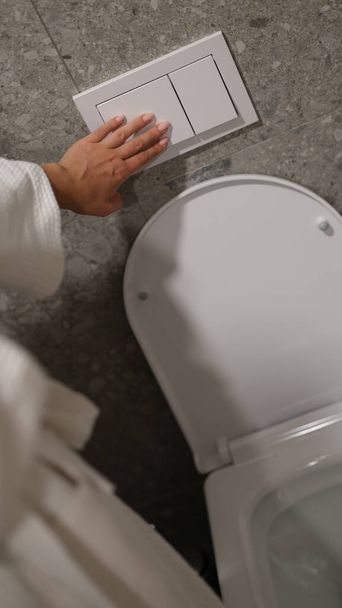 Premere a filo WC economico con due pulsanti separati. Donna preme il pulsante nella toilette - Foto, immagini