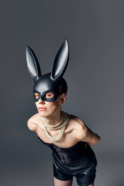 queer person in corset and bdsm bunny mask posing on grey, androgynous, fashion, look at camera - Fotografie, Obrázek