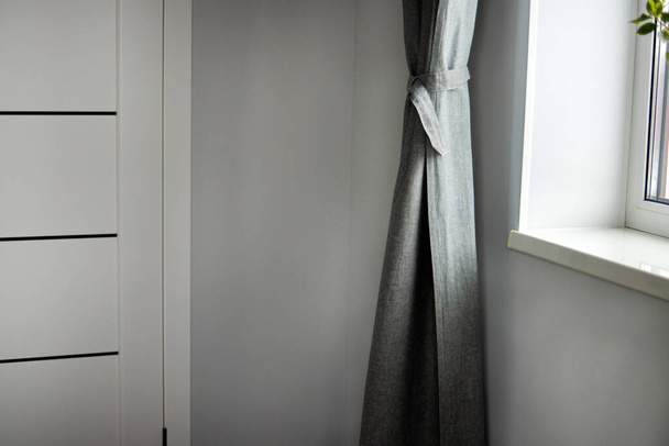 Le lunghe tende di lino grigio sulla finestra. L'interno della casa. - Foto, immagini