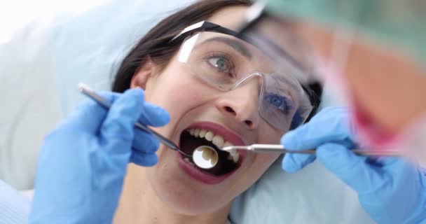 Tandarts voert medisch onderzoek van de patiënt mondholte. Begrip tandheelkundige behandeling - Video