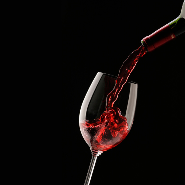 Siyah bir zemin üzerine şarap cam içine kırmızı şarap dökme - Fotoğraf, Görsel