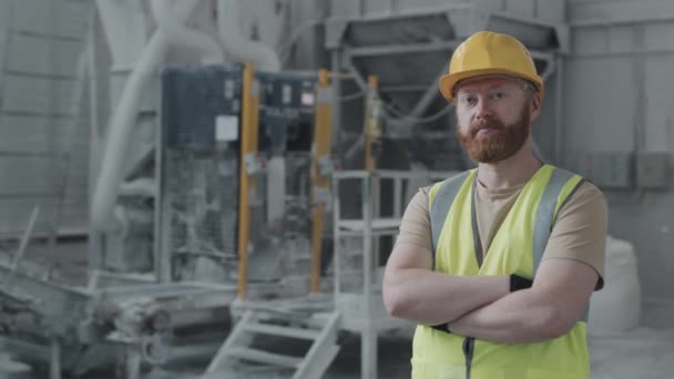 Plan moyen de l'homme caucasien barbu travaillant dans une usine de marbre debout avec les bras croisés regardant caméra - Séquence, vidéo