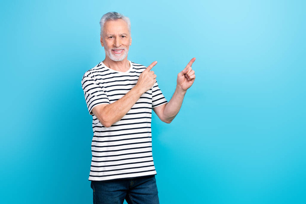 Photo portrait of nice elderly man fingers point empty space promotion wear trendy striped outfit isolated on blue color background. - Valokuva, kuva