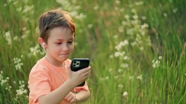 Natures Melodies : A Harmonious Adventure of a Young Boy Immersed in Music and Gentle Movement among the Lush Meadow. Images 4k de haute qualité - Séquence, vidéo