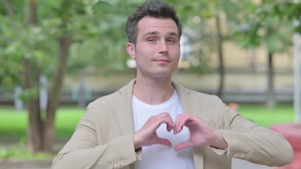 Outdoor Portrait of Casual Young Man with Handmade Heart - Footage, Video
