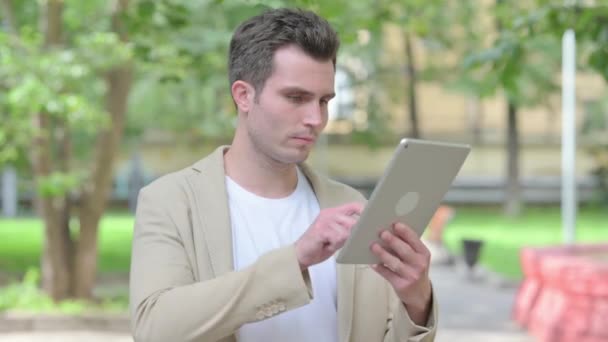 Casual jeune homme en utilisant la tablette extérieure - Séquence, vidéo