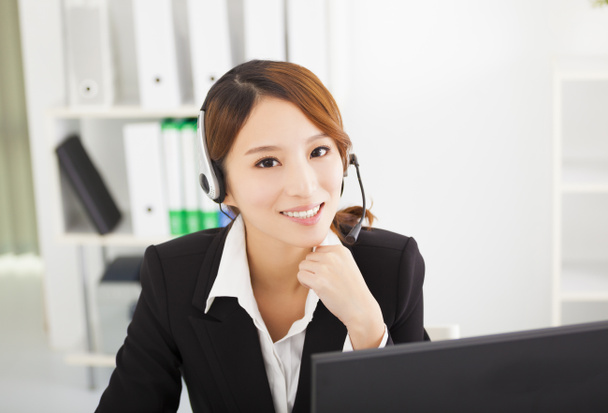 young beautiful businesswoman with headset in office - Photo, Image
