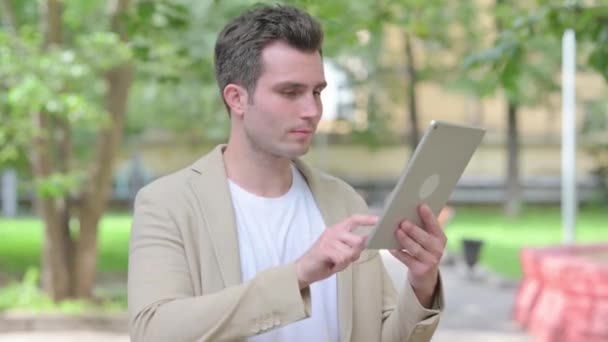 Casual joven haciendo video chat en la tableta al aire libre - Metraje, vídeo