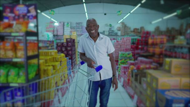 Shopper afro-americano sorridente anziano con carrello nella corsia del supermercato - Foto, immagini