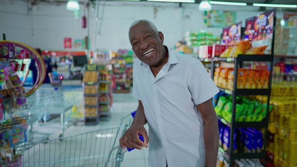 Ritratto di anziano afro-americano sorridente nel supermercato. Una persona nera brasiliana felice agli affari locali - Foto, immagini