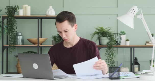 Σε αυτή τη σοβαρή σκηνή, ένας επιχειρηματίας απεικονίζεται κάθεται στο γραφείο του, επιμελώς εργάζονται με έγγραφα, αλλά το πρόσωπό του δείχνει σημάδια απογοήτευσης και απογοήτευσης. - Πλάνα, βίντεο