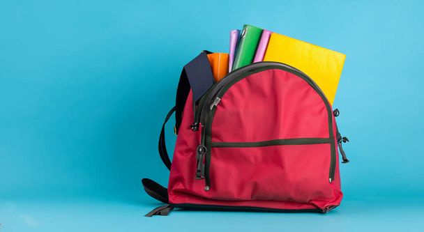 otevřená školní červená taška s knihami na modrém pozadí ve vysokém rozlišení HD - Fotografie, Obrázek