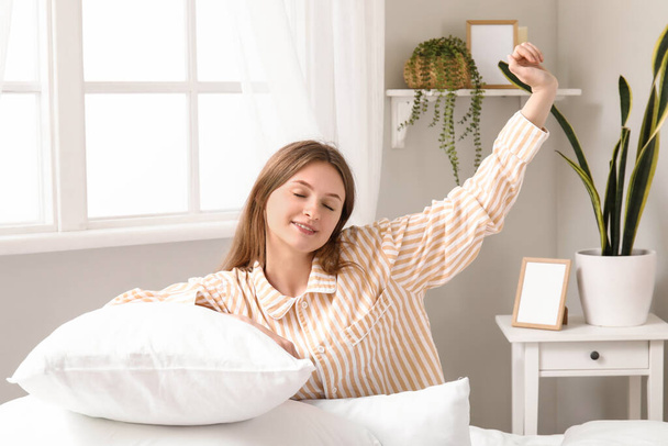 Утро красивой молодой женщины с подушками в мягкой постели - Фото, изображение