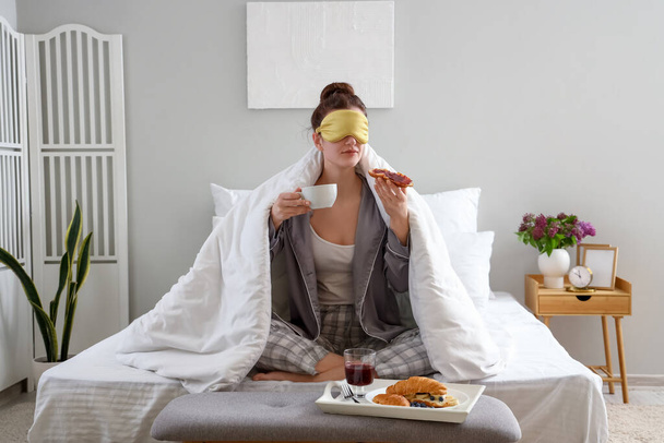 Poranek młodej kobiety jedzącej śniadanie w sypialni - Zdjęcie, obraz