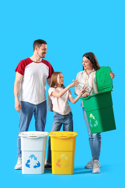 Familie sorteren afval in prullenbak op blauwe achtergrond - Foto, afbeelding