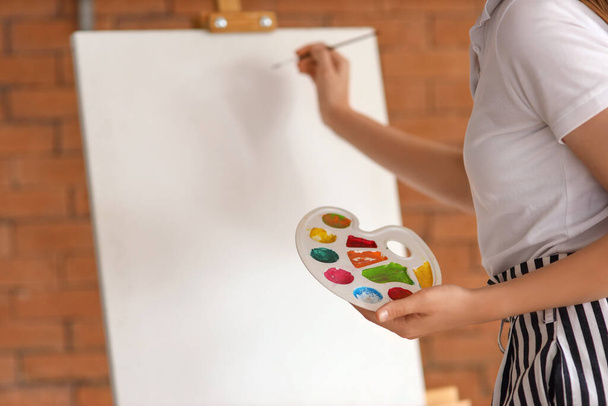 Jonge vrouw schilderen op haar vrije dag thuis, close-up - Foto, afbeelding