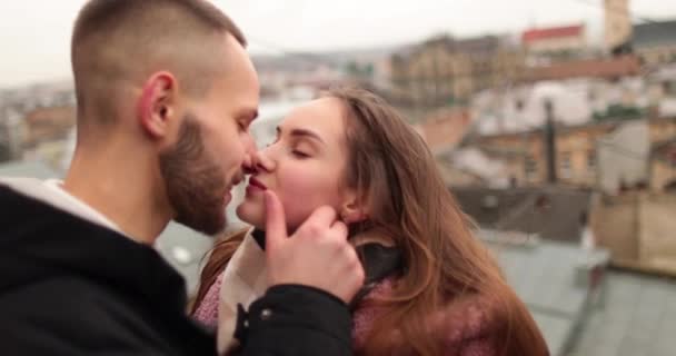 Kisses and hugs of a young couple in love. A romantic meeting of a young couple in the city center on a gloomy autumn day. Happy boy and girl hug, kiss, enjoying time together. - Footage, Video