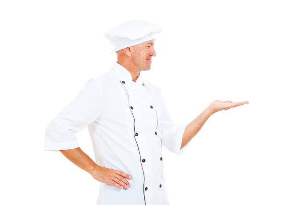 Cheerful chef holding something on his palm - Photo, image