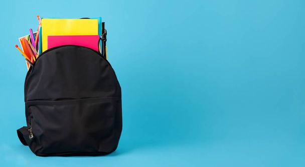 όμορφη σχολική σκούρα τσάντα χρώμα σε μπλε φόντο - Φωτογραφία, εικόνα
