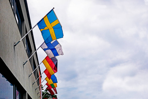 Evropa, Estonsko, Finsko, Německo, Ukrajina, Lotyšsko, Litva vlajky na budově v oblačný den - Fotografie, Obrázek